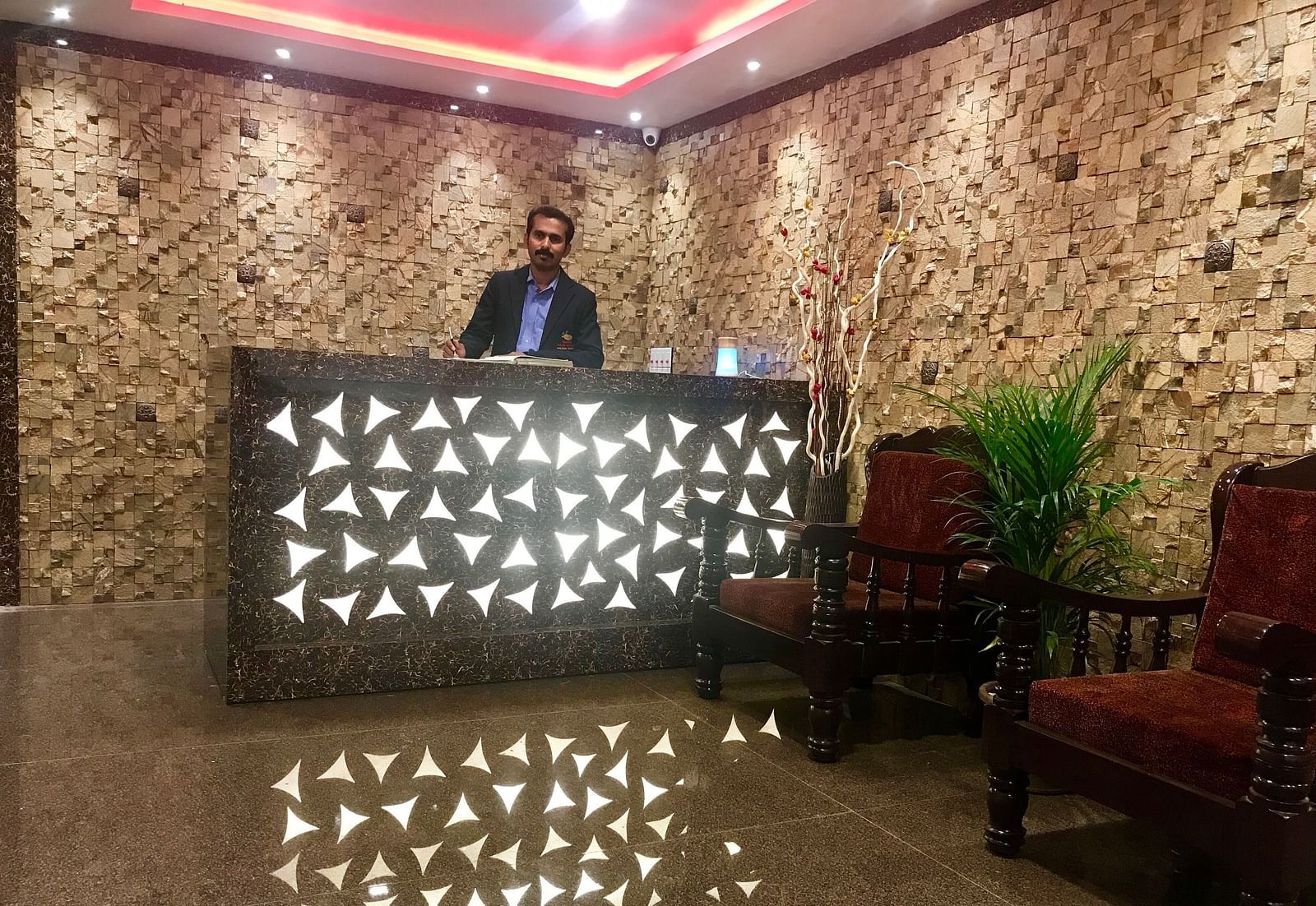 Image of a man standing behind a counter table at Parampara Residency, Kushalnagar..