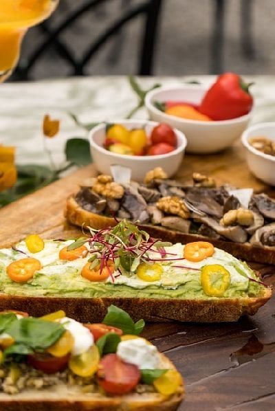 Toasted open sandwich with vegetables and mushrooms, served with condiments and a side of watermelon at Karma Chalets..