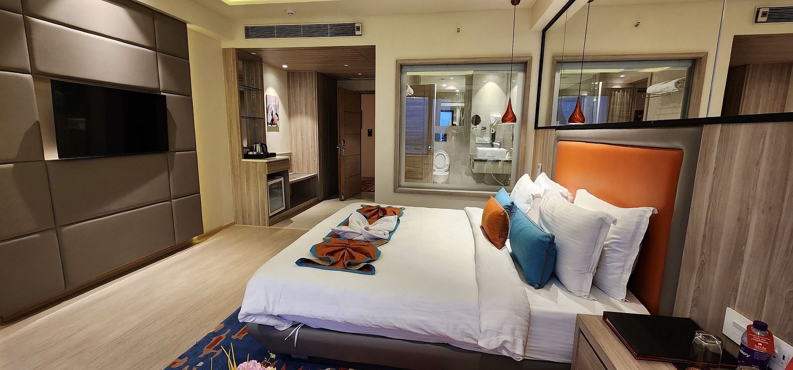 Modern hotel room with sleek furnishings, a comfortable bed, and a partial view of the en-suite bathroom.