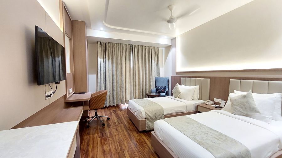  Contemporary twin room at Hotel City Inn, Varanasi, offering sleek furnishings, ambient lighting, and a flat-screen TV.