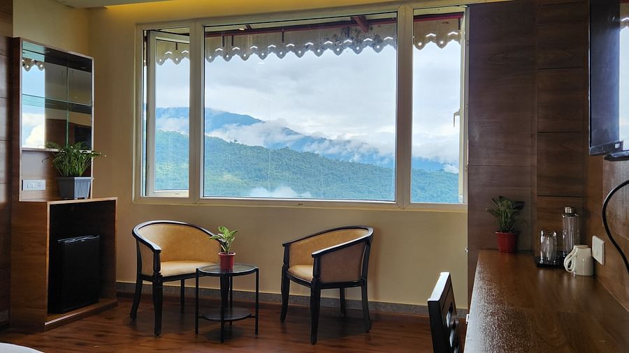 Two chairs placed beside a huge window that offers mountain views | Voyage The Royal Retreat, Gangtok