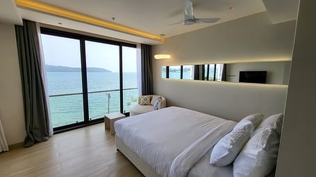 View of a single bed facing the sea from behind in the Double 6ix Sea View with Jacuzzi Double Sized Bed at 6ix Seashore Hotel, Port Blair