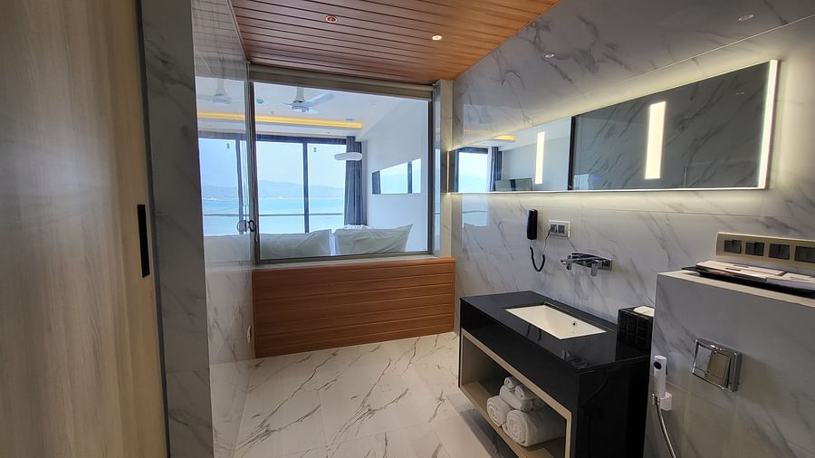 Image of the 6ix Sea View Room taken from its washroom showcasing the sink and two pillows on the double bed at 6ix Hotel, Port Blair 4