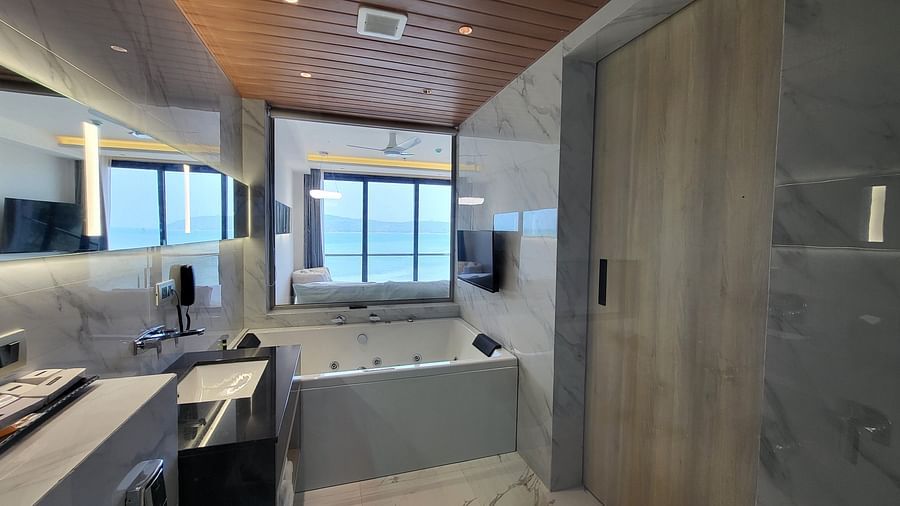 A Jacuzzi and a sink in the washroom in the 6ix sea view room with Jacuzzi at 6ix Seashore Hotel, Port Blair