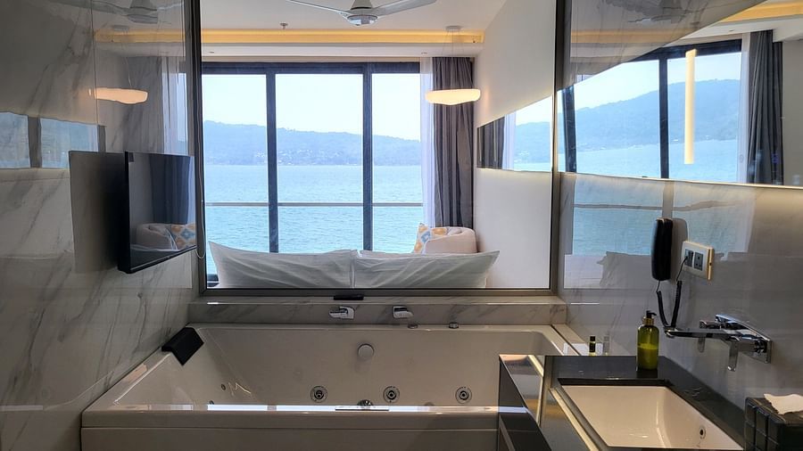 Wide view of the Jacuzzi and a sink with a view of the ocean in the background in the Double 6ix Sea View with Jacuzzi Double Sized Bed at 6ix Seashore Hotel, Port Blair