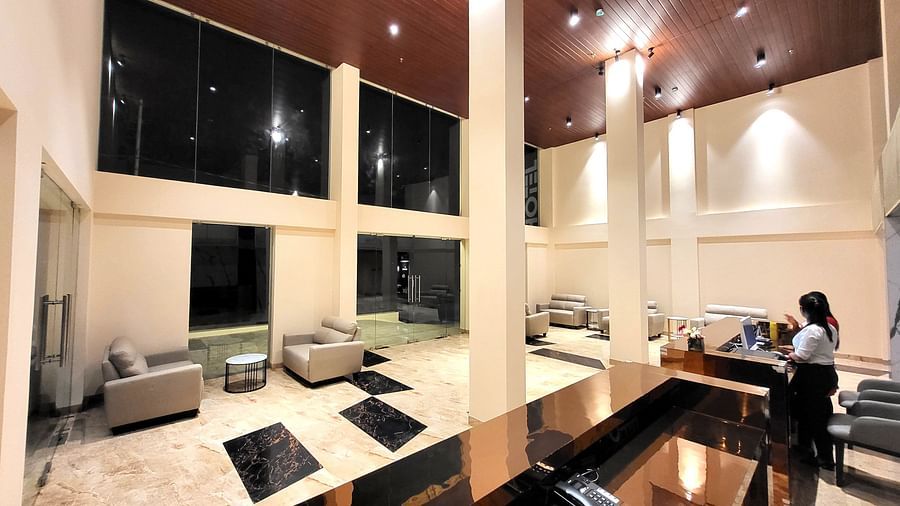 A woman standing on the Reception & view of the Lobby at 6ix Seashore Hotel, Port Blair