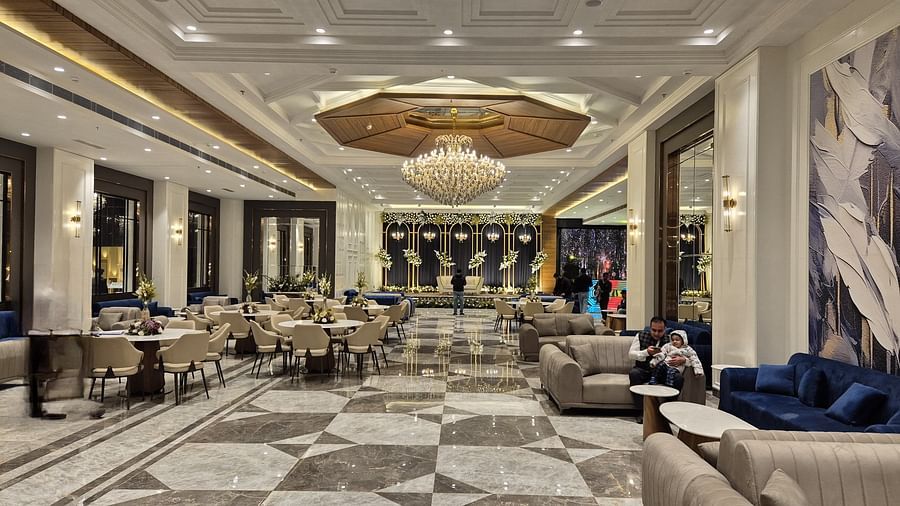 Spacious and modern banquet hall with plush seating and a central chandelier at Ramada by Wyndham Sonipat Murthal