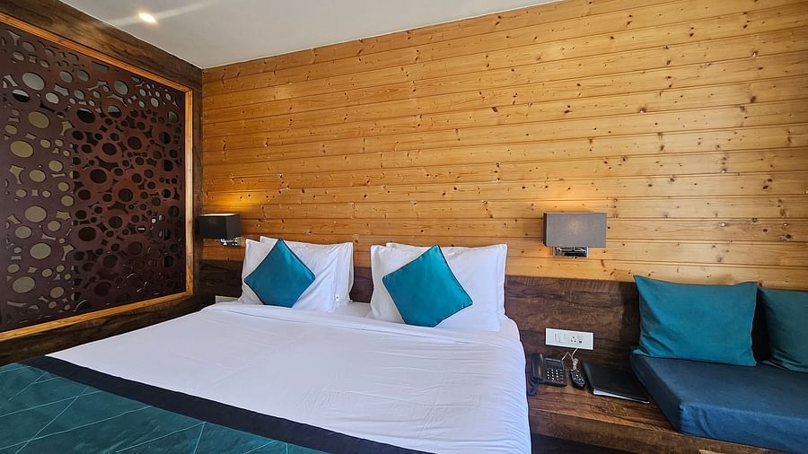 An image of a deluxe suite with a bed, bed side table, lamps, and a couch -Yashshree Sanderling, Darjeeling