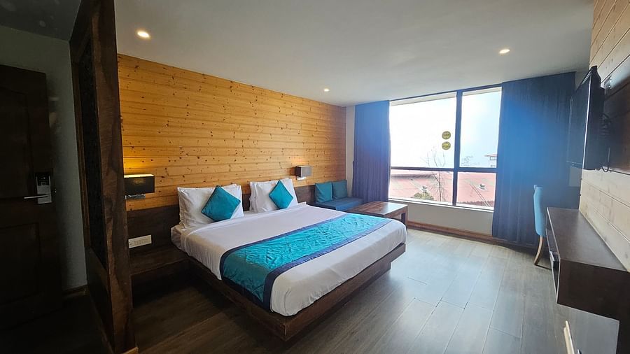 An image of a premium room featuring basic room amenities and an expansive window overlooking the view - Yashshree Sanderling, Darjeeling