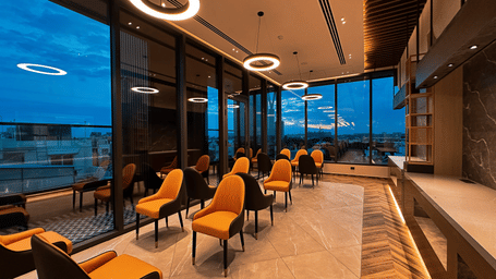 Full view of the restaurant area with sparsely scatered with a bufft counter in the corner at F Hotels, Bengaluru.