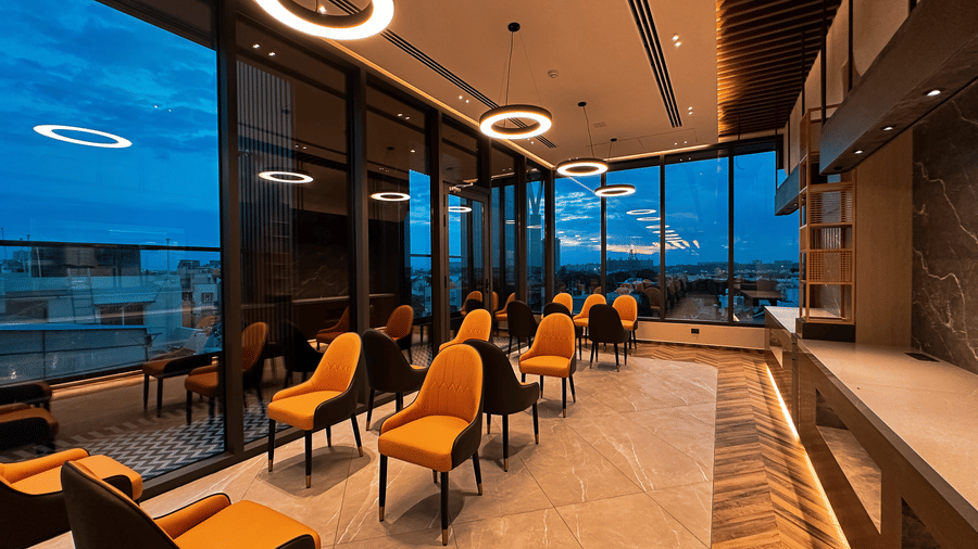 Full view of the restaurant area with sparsely scatered with a bufft counter in the corner at F Hotels, Bengaluru.
