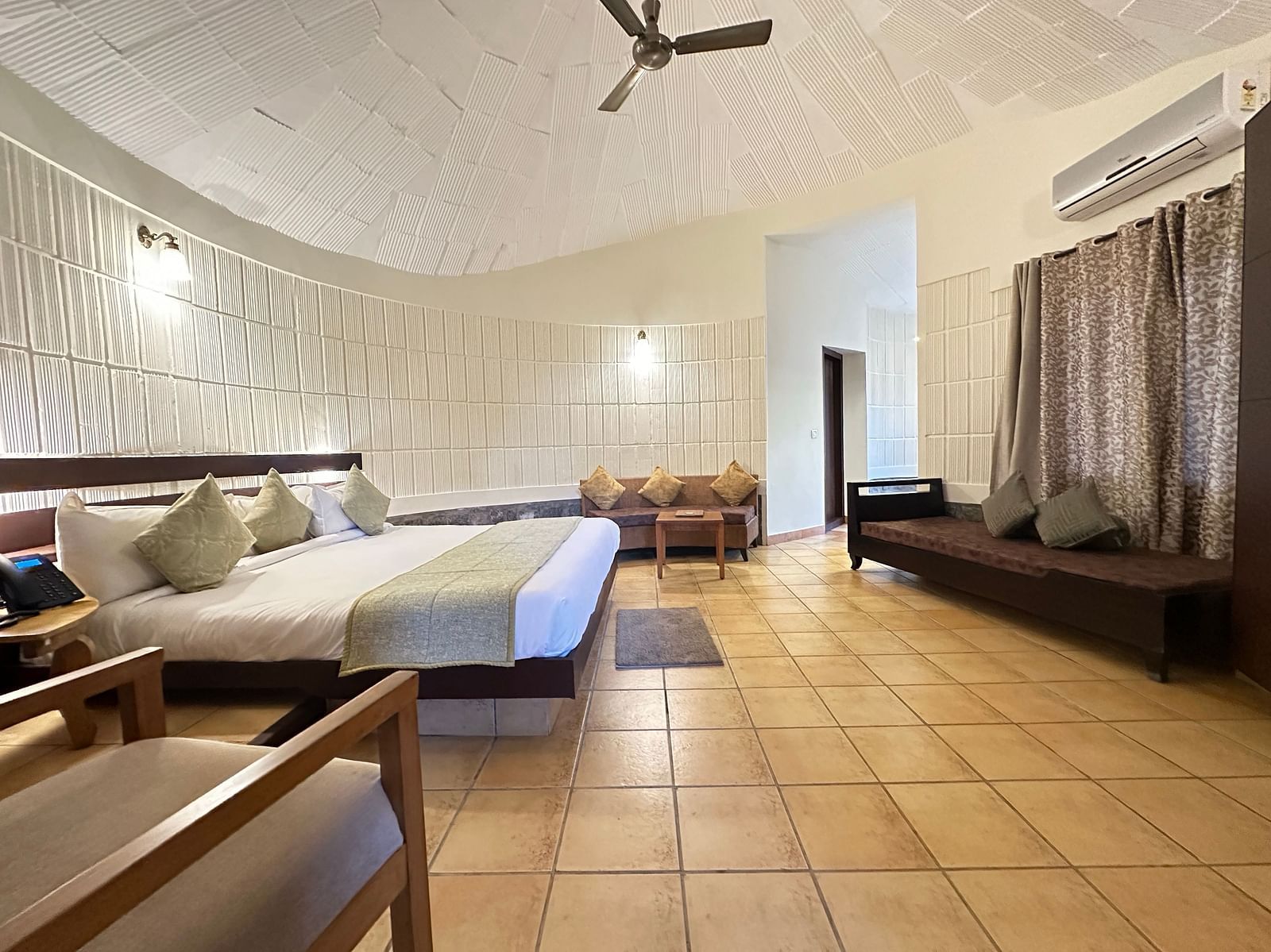 a bedroom with a double bed and a single bed opposite to it, with chairs in the room - Kadkani River Resort, Coorg