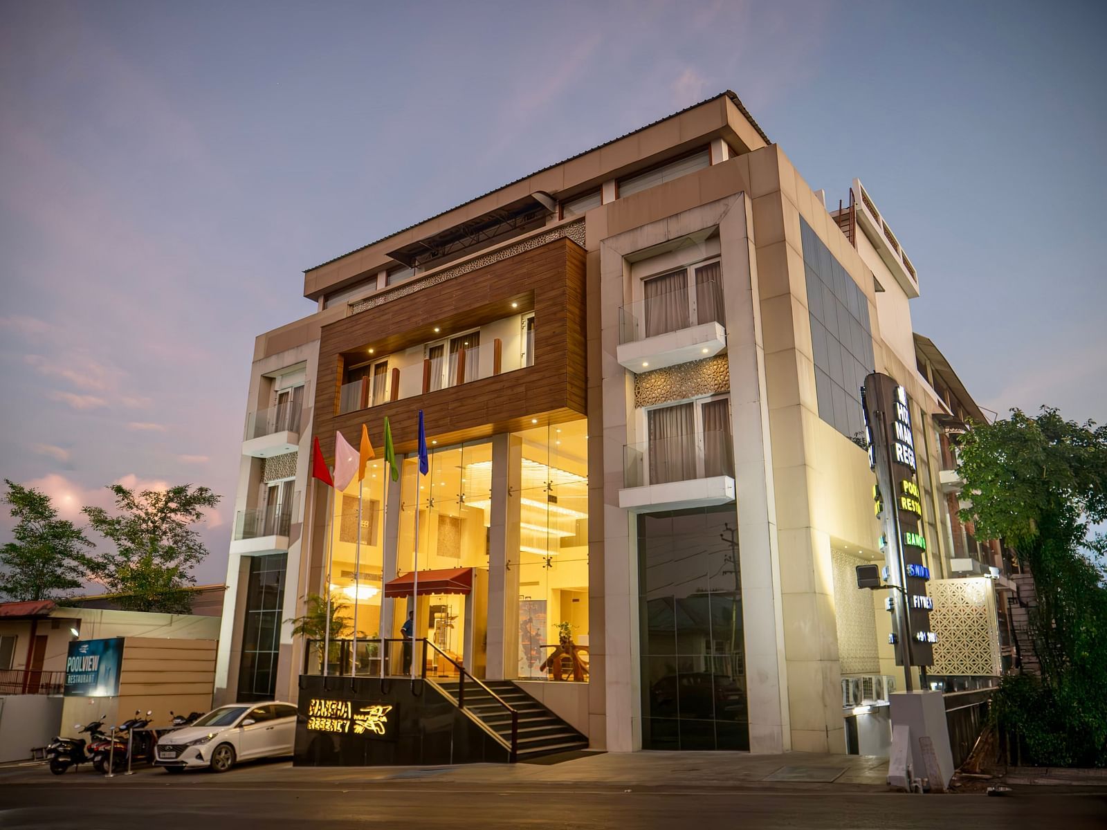 The exterior of Mansha Hotel Regency, a multi-storey building with a modern design, captured during early evening | Mansha Hotels