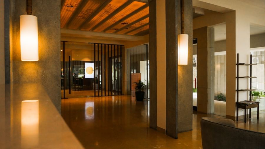 A warm and welcoming hotel lobby or corridor with elegant lighting and wooden accents, guiding guests at Shilton Dee Cee.