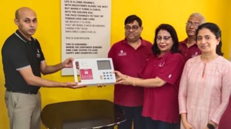 A group of people smiling as they pose with a certificate and a small gift box - Lords Hotels & Resorts