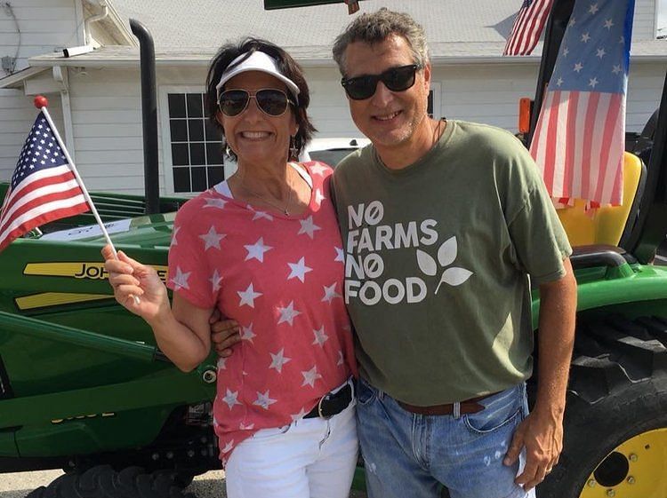 a man and a woman holding a paper flag of the united states of america