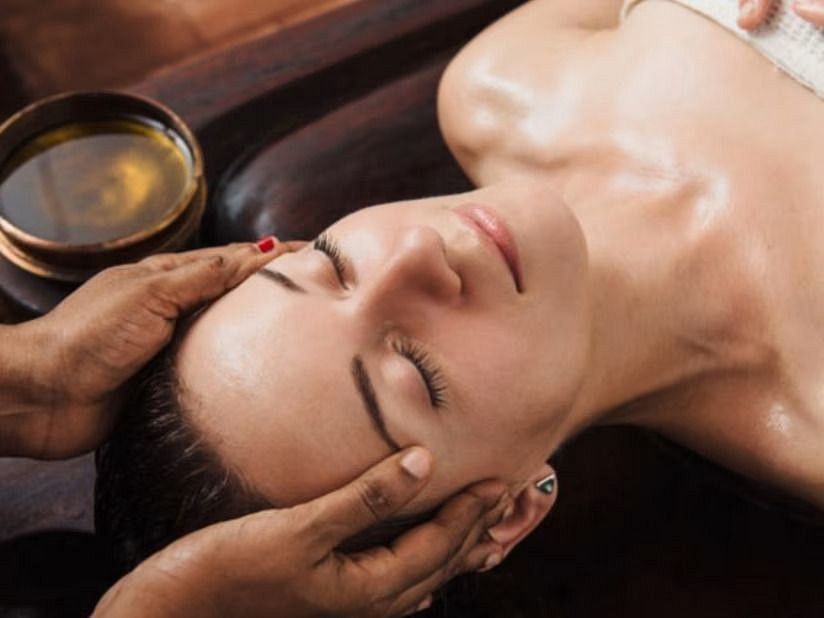 A woman receiving traditional Ayurvedic head massage at YO1 Health Resort, Catskills, New York.
