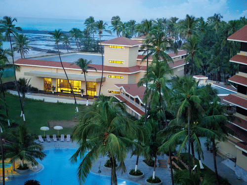 Elevated view of The Retreat Hotel and Convention Centre showcasing the main building, surrounding palm trees and the serene pool area within the hotel premises.