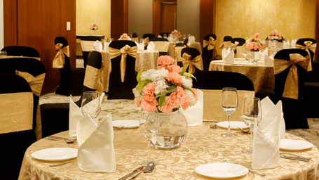 Elegant wedding banquet table setup with floral centre pieces in a Gurgaon hotel.