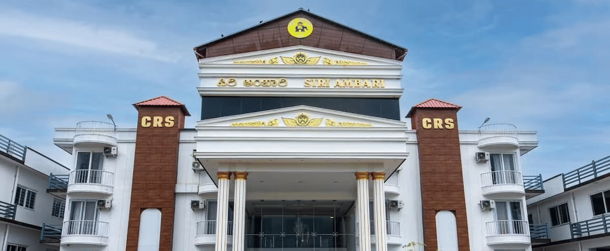 Grand exterior view of Siri Ambari Resorts and Spa, featuring a majestic white building with landscaped gardens in front.