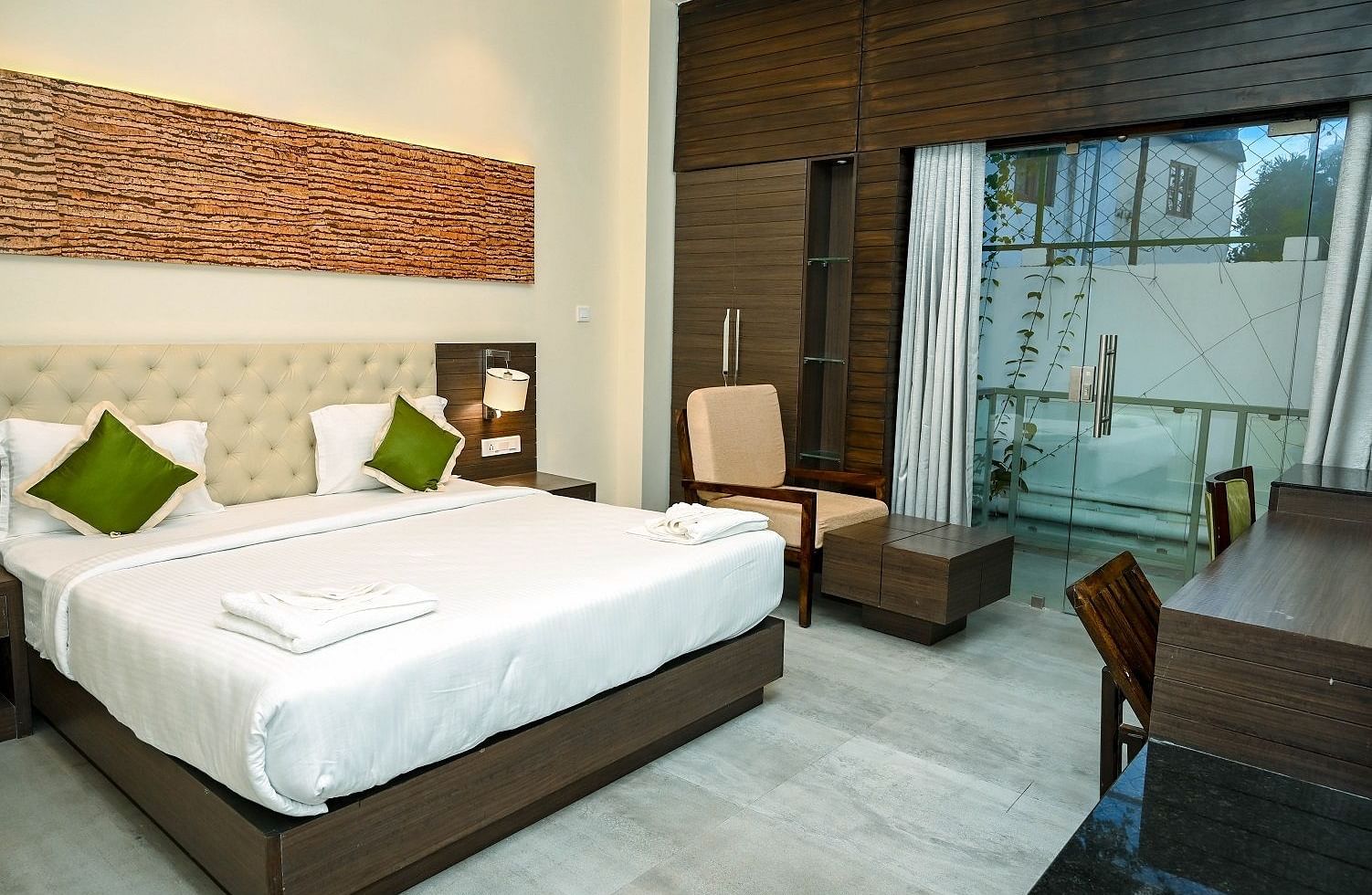 A bright hotel bathroom with a freestanding white bathtub, a toilet, a modern basin, and a large mirror, with light-coloured tiled walls - Sea Hills Hotels, Sri Vijaya Puram (Port Blair)