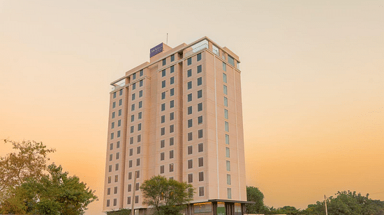Exterior view of Clarks Inn Suites Jaipur on Ajmer Road, showcasing its elegant facade against a serene evening sky