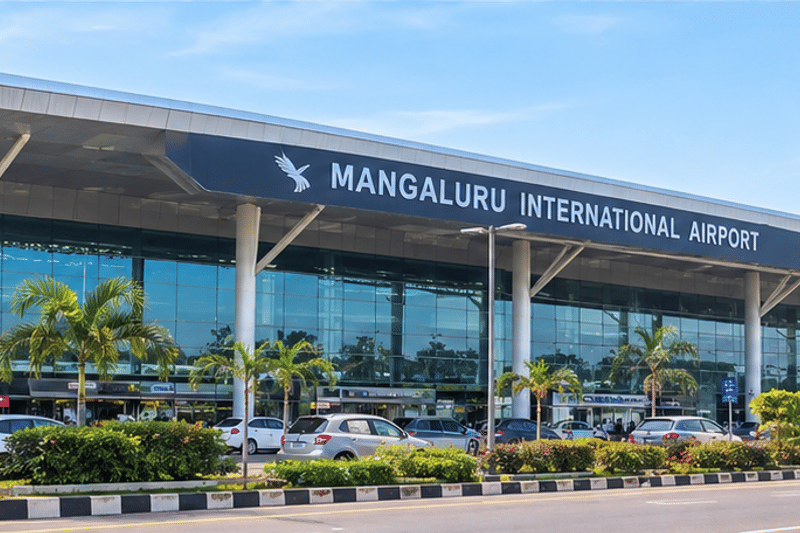 Glass-fronted terminal of Mangaluru International Airport, lined with palm trees
