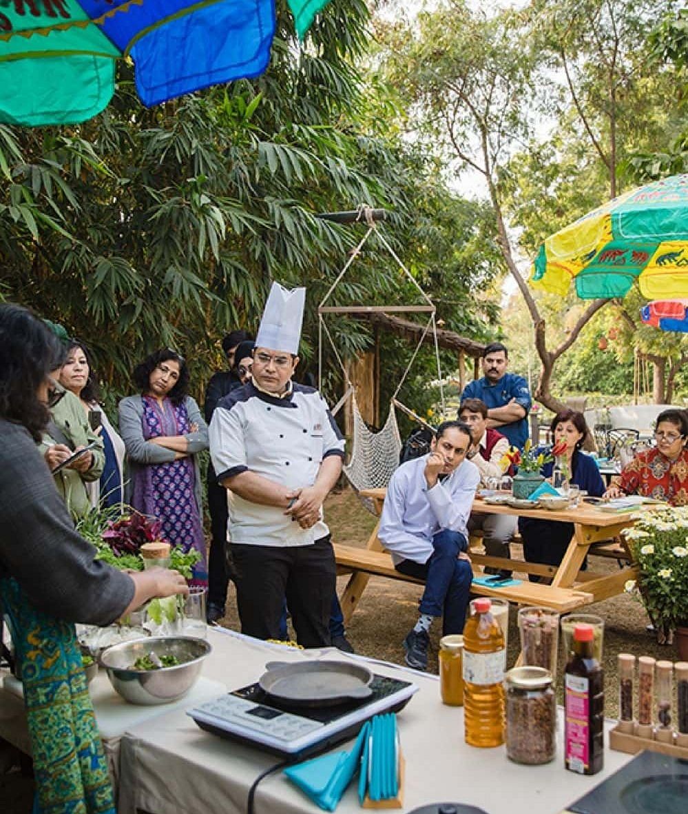 Outdoor cooking demonstration or tasting event with a group of people and a chef at Karma Chalets.