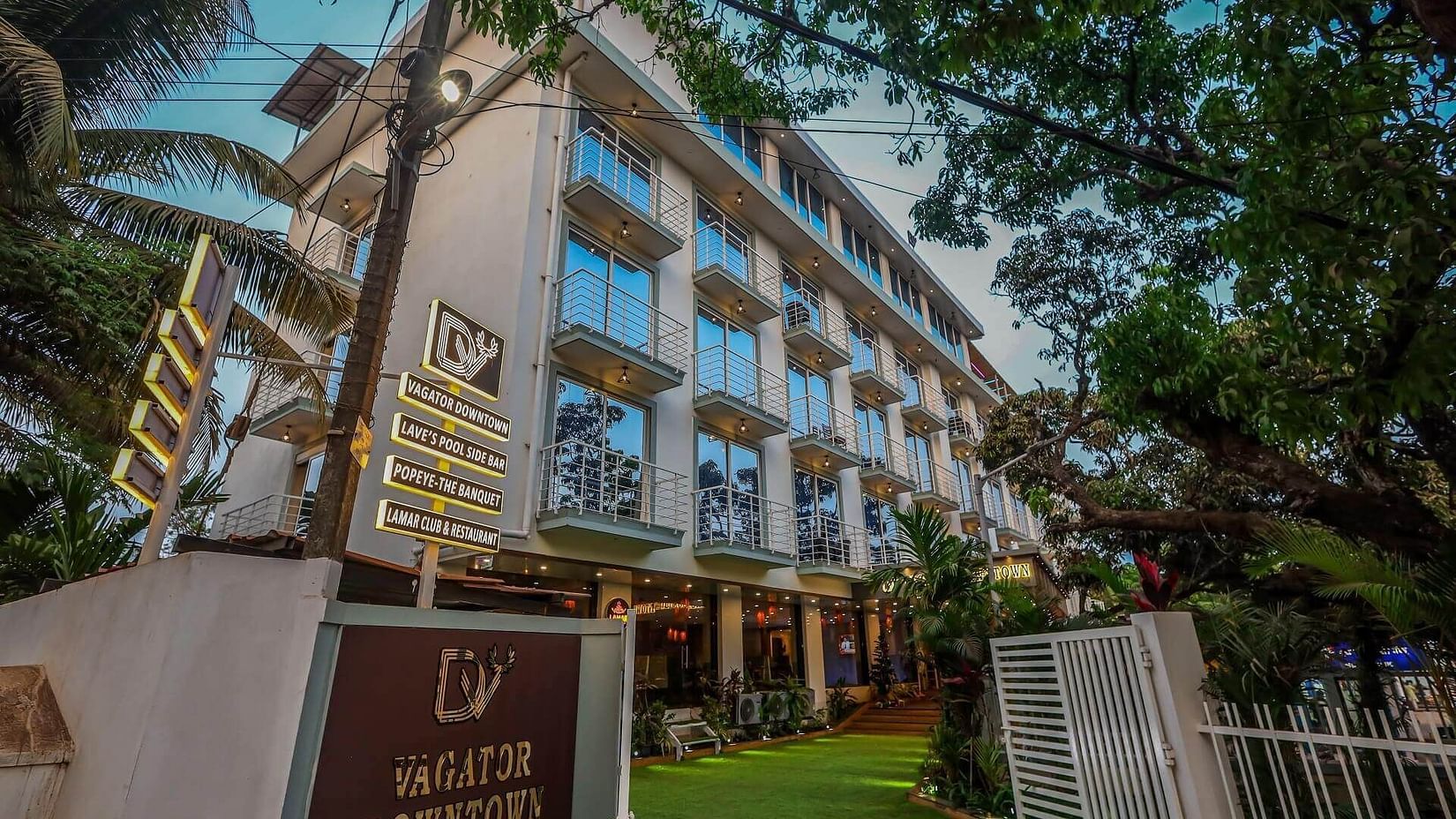 Facade of  Vagator Downtown, Goa, surrounded by trees 