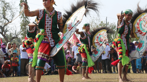 Group of people in a colourful attire showcasing intricate footwork