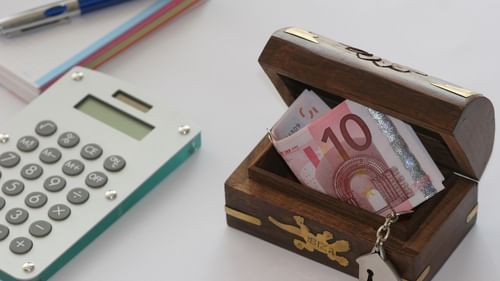 A calculator and bills in a small box