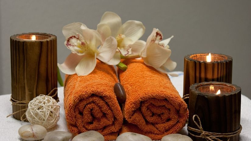 A close up shot of a table with towels, candles and petals of flowers - Abad Copper Castle, Munnar