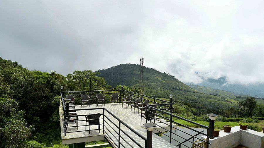 Shot of the sit out at the villa during the bright day Shot of the balcony at the villa with chairs kept | Ibex Stays and Trails, Valparai (Tale Rock)