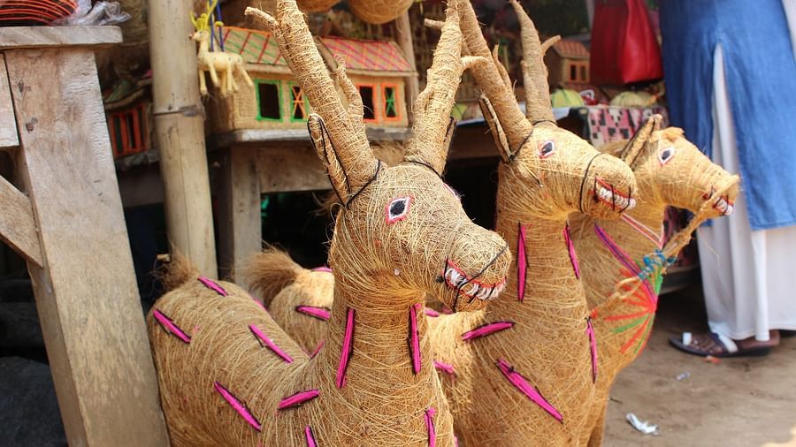  Handcrafted straw deer ornaments, intricately woven and adorned with colourful threads, displayed at a local craft market.