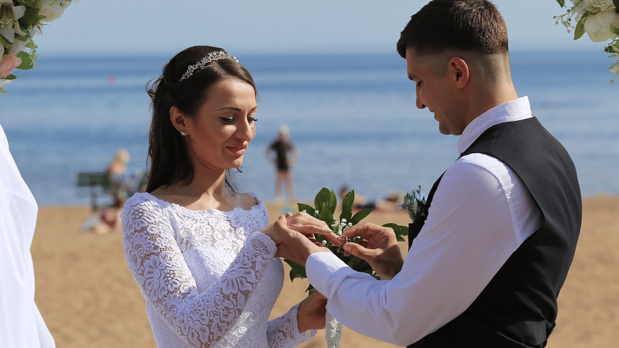 alt-text Groom placing wedding ring on the bride at a beach wedding in Andaman
