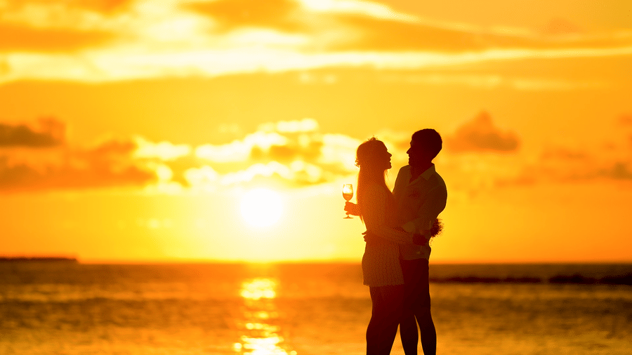 Silhouette of a couple holding each other on a beach at sunset, capturing an Andaman and Nicobar Islands destination wedding moment.