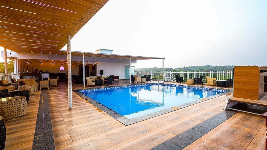 Rooftop swimming pool with seating area on the side at Vagator Downtown, Goa