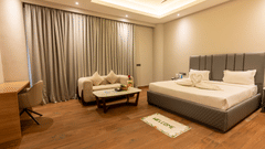 Twin-bed room with soft lighting, curtains, and seating area at Silver Sand Sea Princess Beach Resort, Port Blair.