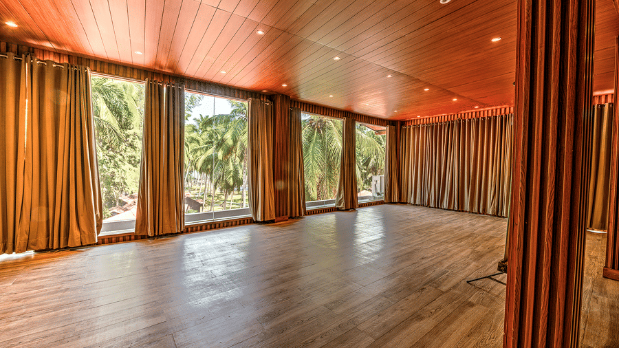 A spacious area with wooden flooring and a pleasant view from the window in the Conference Hall at Silver Sand Beach Resort, Havelock.