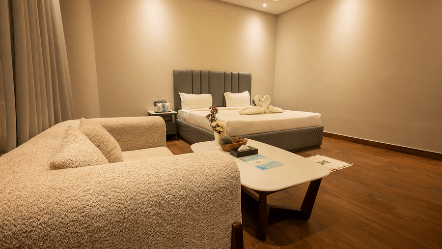 Cozy room with sofas and twin beds in warm tones at Silver Sand Sea Princess Beach Resort, Port Blair.