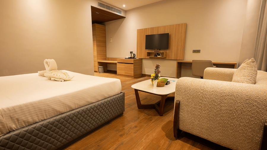 Stylish bedroom with double bed, sofa, and work desk at Silver Sand Sea Princess Beach Resort, Port Blair.