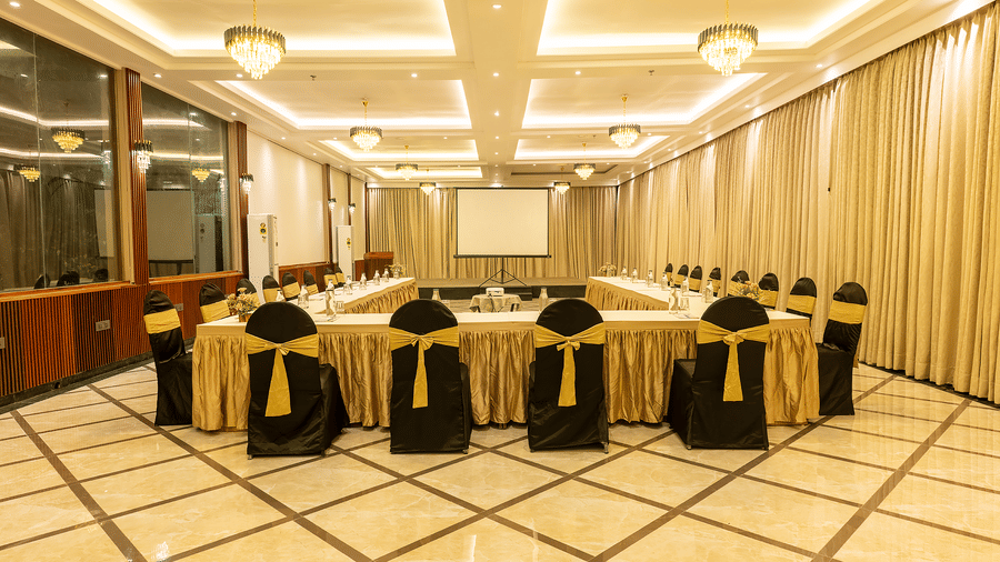 Banquet hall with gold-accented chair covers and bright lighting at Silver Sand Sea Princess Beach Resort, Port Blair.