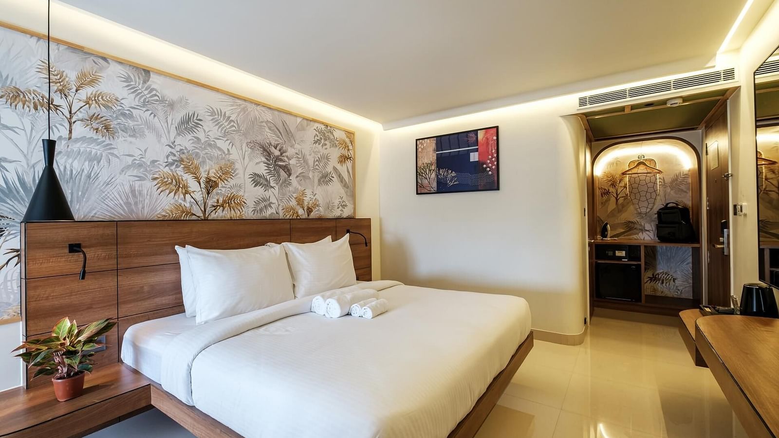 A spacious room at Indie Stays, Jaipur, featuring a large bed with a wooden headboard and warm lighting.