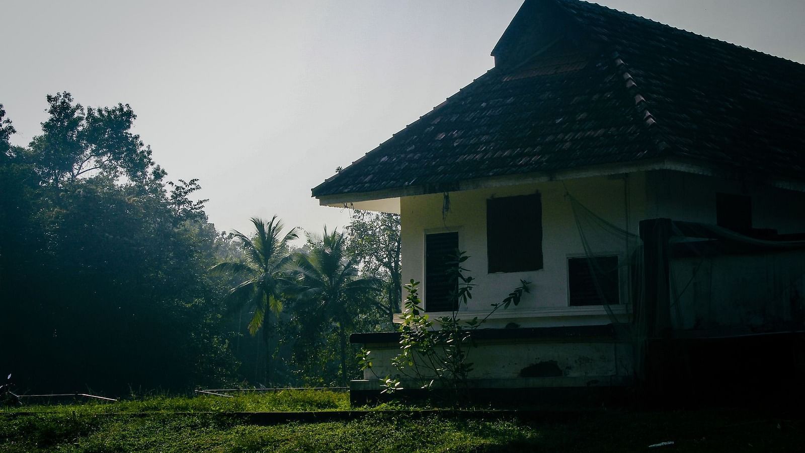 an old temple temple building situated on a platform filled with lush greenery