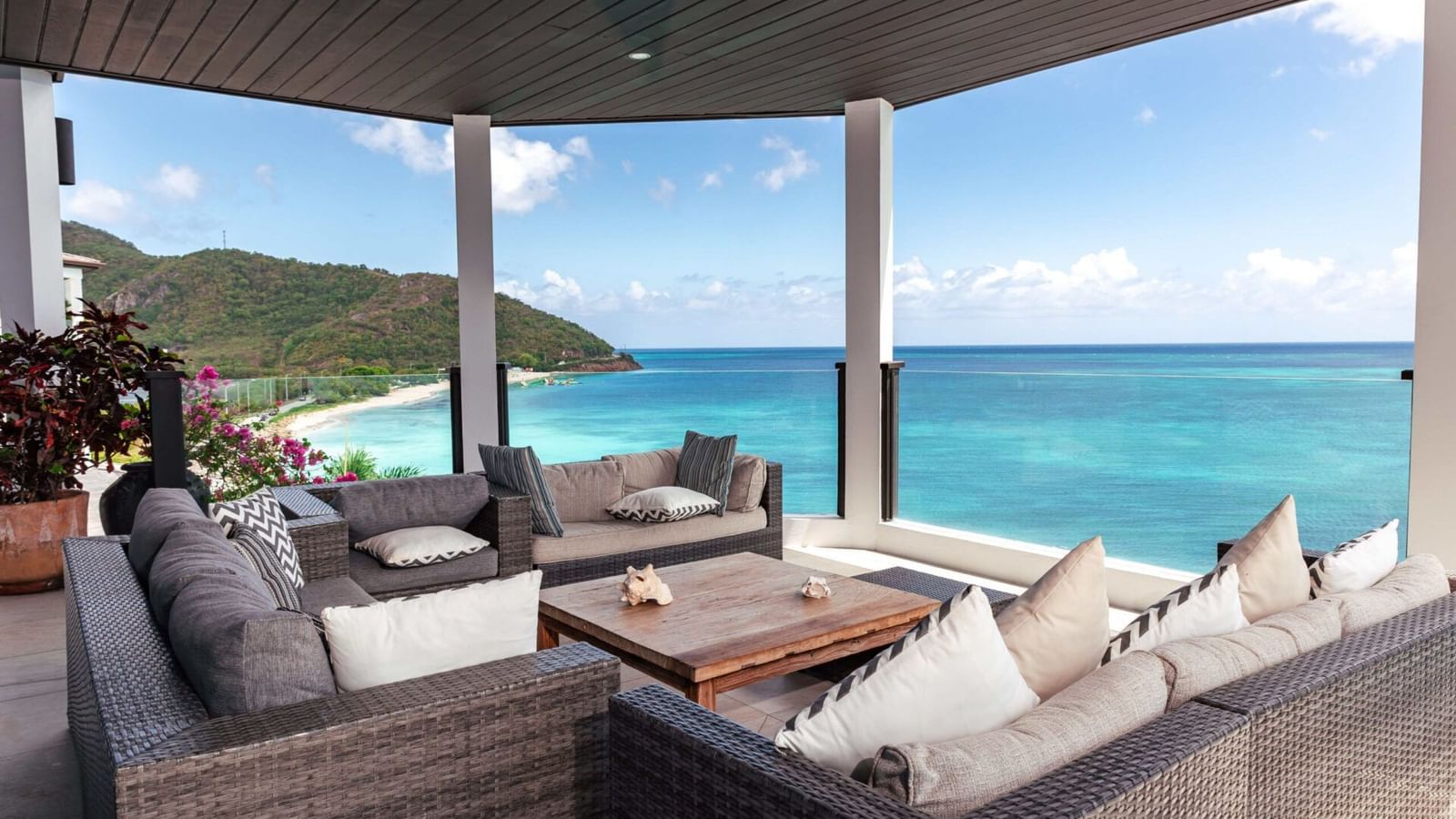 A luxurious covered terrace with plush seating and panoramic ocean views - Tamarind Hills Resort and Villas - Antigua