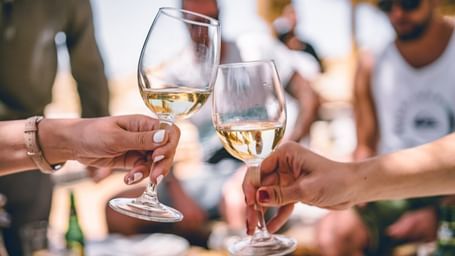 Group toasting with glasses of white wine at a celebration.