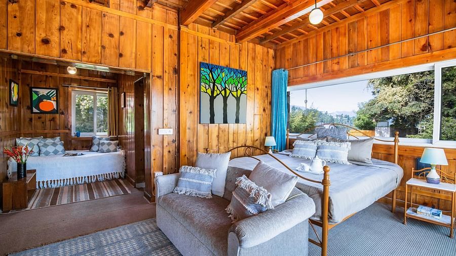 An mage of a master suite bedroom at avalon cottages with a seating arrangements near the window