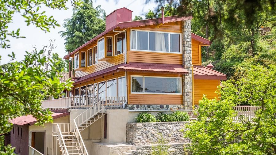 An image of a cottage with stairs and balconies at each floor surrounded by trees everywhere -  Avalon Cottages, Kanatal