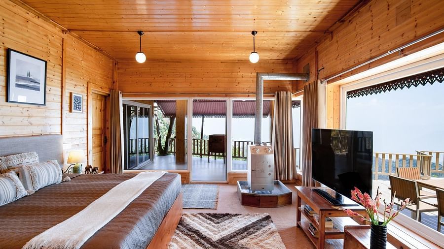 An image of full view of the room with a bed tv heater and patio | Avalon Cottages, Kanatal
