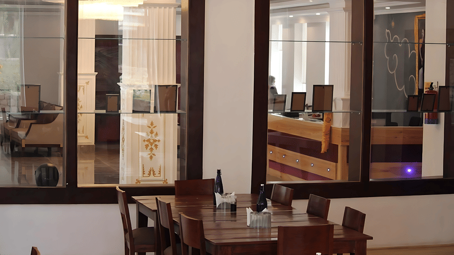 View from the dining area toward the reception desk through large glass partitions at Hotel Dekiling by Eastlynn Collections, Leh.
